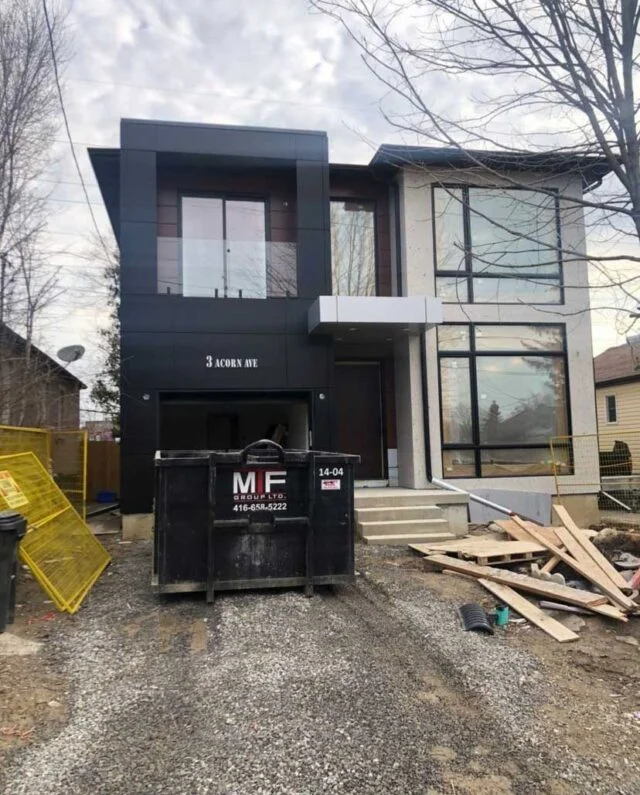 Dumpster bin placed beside house