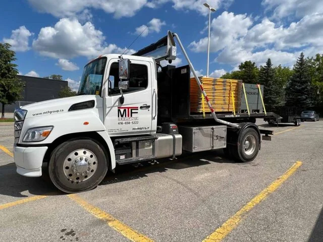 MTF Group roll-off truck delivering dumpster bin